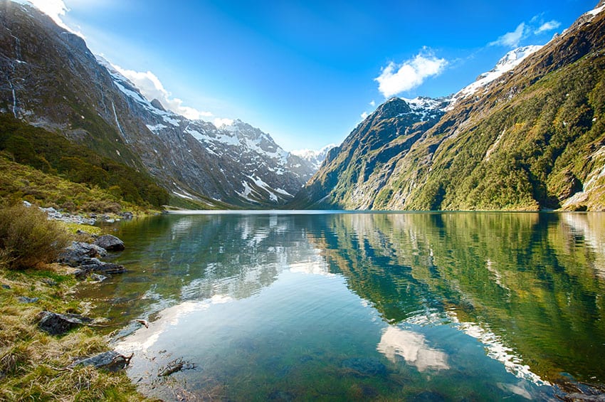 Peaks of Darran Mountains reflecting in a Lake Marian, Fiordland national park, New Zealand South island