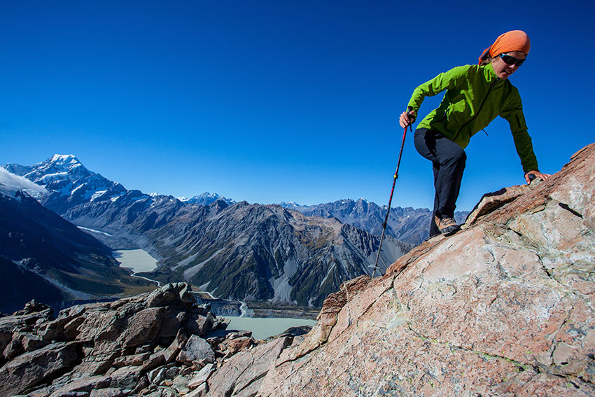Young woman climbing mountain ridge in the Alps