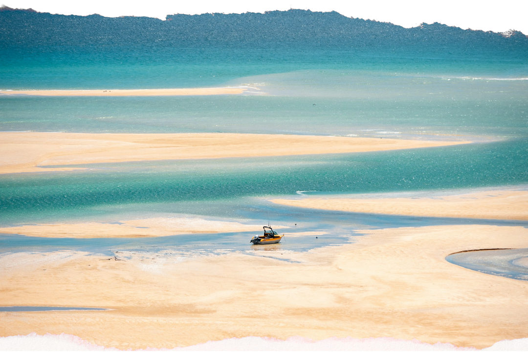 Boat passing the granite headlands of Abel Tasman National Park at sunrise