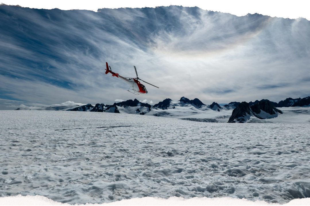 Scenic helicopter flight above a snowy New Zealand glacier