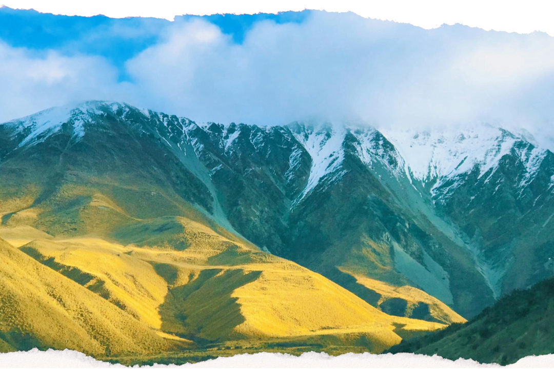 Open scenic road winding through Canterbury with snow-capped mountains ahead